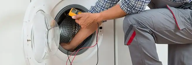 Dryer repair technician inspecting and repairing a clothes dryer in Long Beach, CA