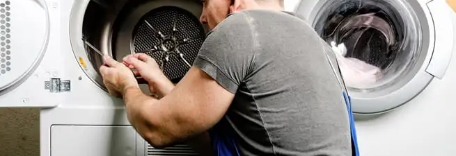 Dryer repair technician fixing a clothes dryer drum in Long Beach, CA