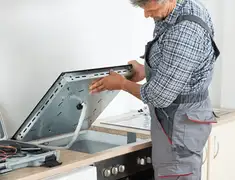 Appliance repair technician installing a built-in cooktop in Long Beach, CA