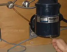 Garbage disposal repair technician tightening the mounting ring under a sink in Long Beach, CA