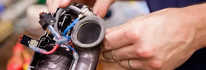 Vacuum repair technician reconnecting wiring and components in Long Beach, CA