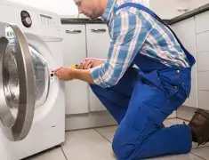 Washing machine repair technician servicing a front-load washer in Long Beach, CA