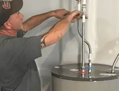 Water heater repair technician tightening supply line connections in Long Beach, CA
