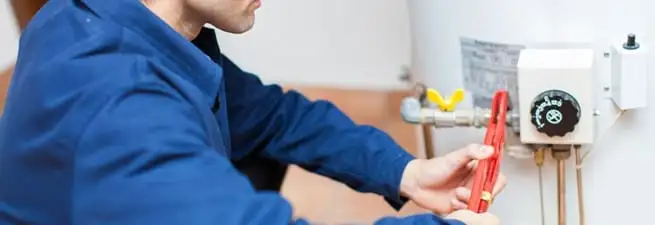 Water heater repair technician adjusting the temperature control and gas valve in Long Beach, CA
